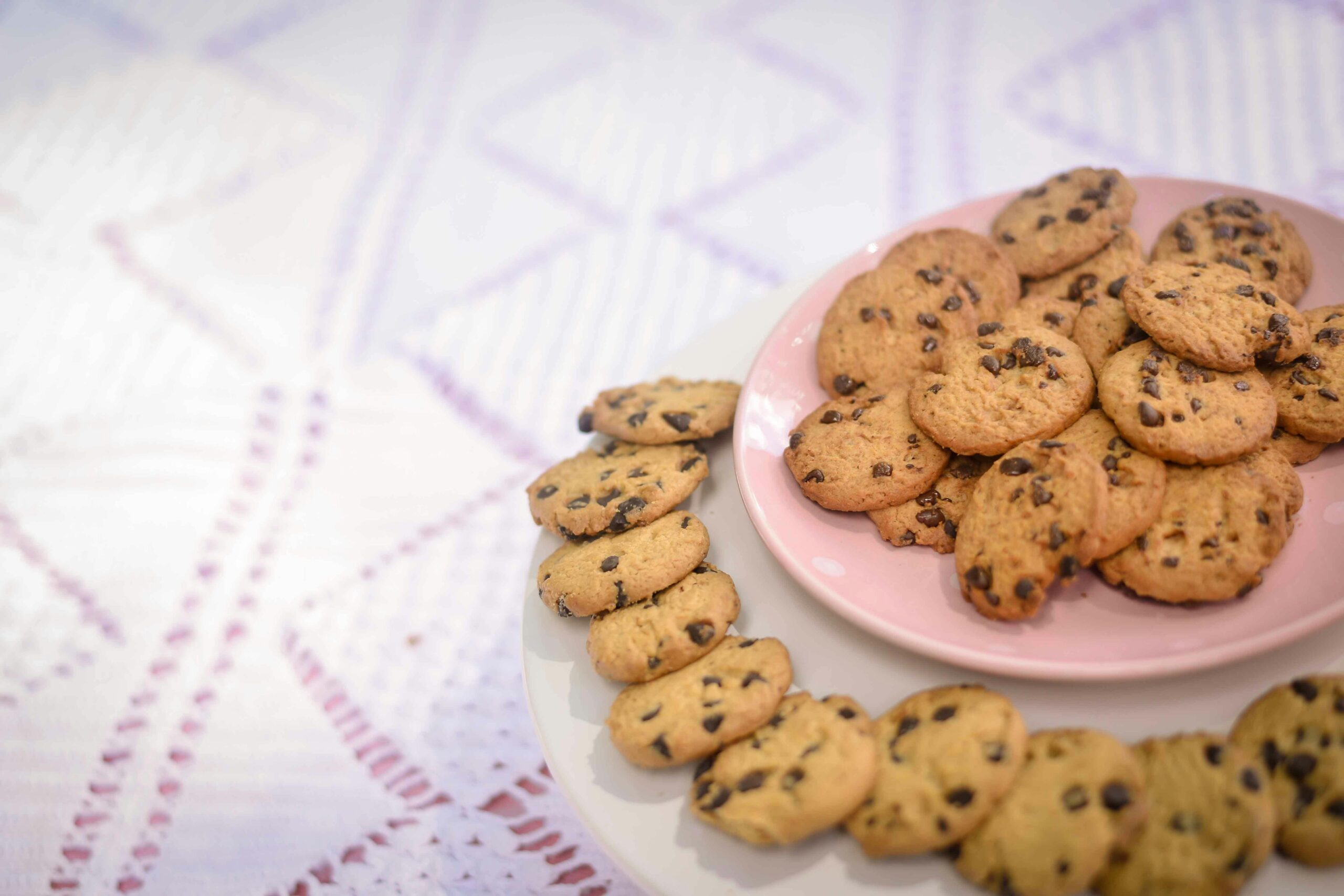 Plate of freshly baked chocolate chip cookies on a decorative setting.